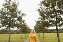Вид сзади на прогулку блондинки в парке — стоковое фото