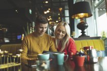 Heureux couple discutant sur la carte de menu dans le café — Photo de stock
