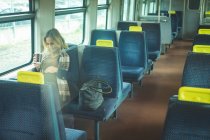 Вагітна жінка торкається свого живота під час подорожі в поїзді — стокове фото