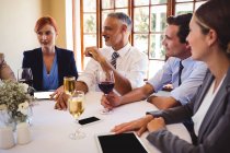 Business people interacting with each other on table in restaurant — Stock Photo
