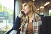 Красива вагітна жінка розмовляє по мобільному телефону під час подорожі в поїзді — стокове фото