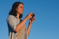 Красивая женщина рассматривает фотографии на камеру — стоковое фото