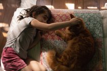 Невинная девушка играет с котом дома — стоковое фото