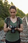 Женщина просматривает фотографии на цифровой фотоаппарат — стоковое фото