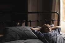 Schöne Frau entspannt sich auf dem Bett im Schlafzimmer zu Hause — Stockfoto