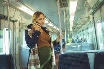 Belle femme enceinte parlant sur mobile en voyage en train — Photo de stock
