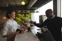 Офіціант, який подає каву жінці-виконавцю на стійці в офісних кафетеріях — стокове фото