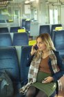 Beautiful pregnant woman talking on mobile phone while travelling in train — Stock Photo