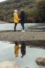 Щаслива пара тримає руки біля річки — стокове фото