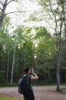 Donna cliccando foto con macchina fotografica nella foresta — Foto stock