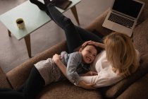 Madre e hija divirtiéndose en la sala de estar en casa - foto de stock