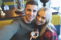 Glückliches Paar blickt in Restaurant in die Kamera — Stockfoto