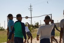 Діти грають у футбол на землі в сонячний день — стокове фото