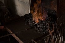 La herradura se calienta en el fuego en la fábrica - foto de stock