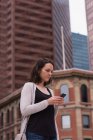 Beautiful woman using mobile phone in the city — Stock Photo