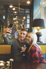 Heureux couple prendre selfie dans restaurant — Photo de stock