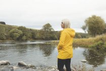 Vue latérale de la femme debout près de la rivière — Photo de stock