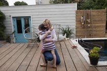 Mãe abraçando sua filha no quintal em casa — Fotografia de Stock