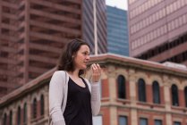 Beautiful woman talking on mobile phone in the city — Stock Photo