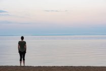 Visão traseira da mulher em pé na praia — Fotografia de Stock