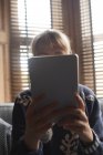 Gros plan de la femme utilisant une tablette numérique à la maison — Photo de stock