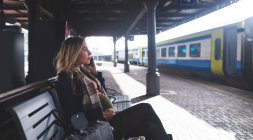 Side view of pregnant woman talking on mobile phone at railway station — Stock Photo