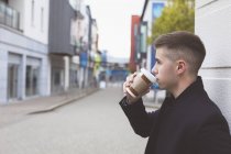 Vista lateral del hombre tomando café en la ciudad - foto de stock