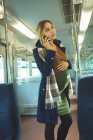 Красивая беременная женщина разговаривает по мобильному телефону во время поездки на поезде — стоковое фото