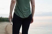 Mittelteil einer Frau, die Tagebuch führt, während sie am Ufer steht — Stockfoto