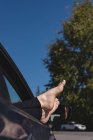 Baixa seção de mulher relaxante com os pés para cima em um carro — Fotografia de Stock