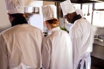 Вид сзади на повара, работающего на кухне в ресторане — стоковое фото
