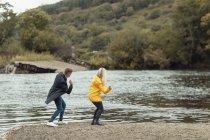Jeune couple s'amusant près de la rivière — Photo de stock