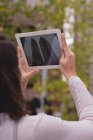 Жінка натискає фотографії будівлі з цифровим планшетом у місті — стокове фото