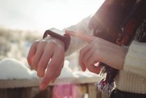 Metà sezione di donna controllando il suo smartwatch — Foto stock