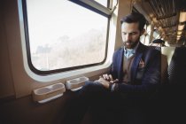 Geschäftsmann checkt Zeit auf Smartwatch während Zugfahrt — Stockfoto