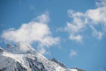 Tranquil view of beautiful snowy mountain range against blue sky and clouds — Stock Photo
