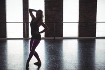 Mujer practicando un movimiento de baile en estudio de baile - foto de stock