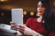 Крупный план женщины, использующей цифровой планшет в ресторане — стоковое фото