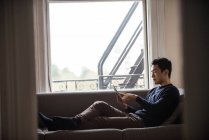 Homem usando tablet digital na sala de estar em casa — Fotografia de Stock