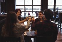 Щасливі друзі тости з пивними келихами в барі — стокове фото