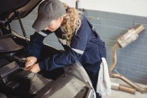 Femme mécanicien entretien voiture au garage de réparation — Photo de stock