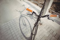 Fahrrad im Sonnenlicht an Geländer gelehnt — Stockfoto