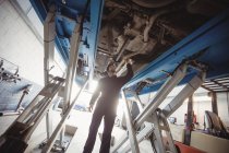 Mechaniker begutachtet Auto in Werkstatt — Stockfoto
