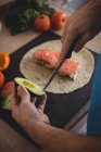 Primo piano di mani maschili che tagliano l'avocado in cucina a casa — Foto stock