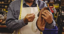 Sección media del zapatero aplicando pegamento en el zapato en el taller - foto de stock