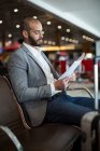 Бізнесмен читає документ у зоні очікування терміналу аеропорту — стокове фото