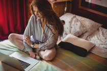 Mulher bonita usando laptop no quarto em casa — Fotografia de Stock