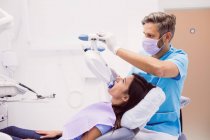 Paziente di sesso femminile che riceve un trattamento dentale da ortodontista di sesso maschile presso la clinica dentistica — Foto stock