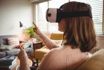 Жінка використовує окуляри віртуальної реальності вдома — стокове фото