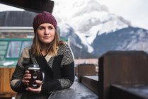 Frau in Winterkleidung hält Bierglas auf Außenterrasse — Stockfoto
